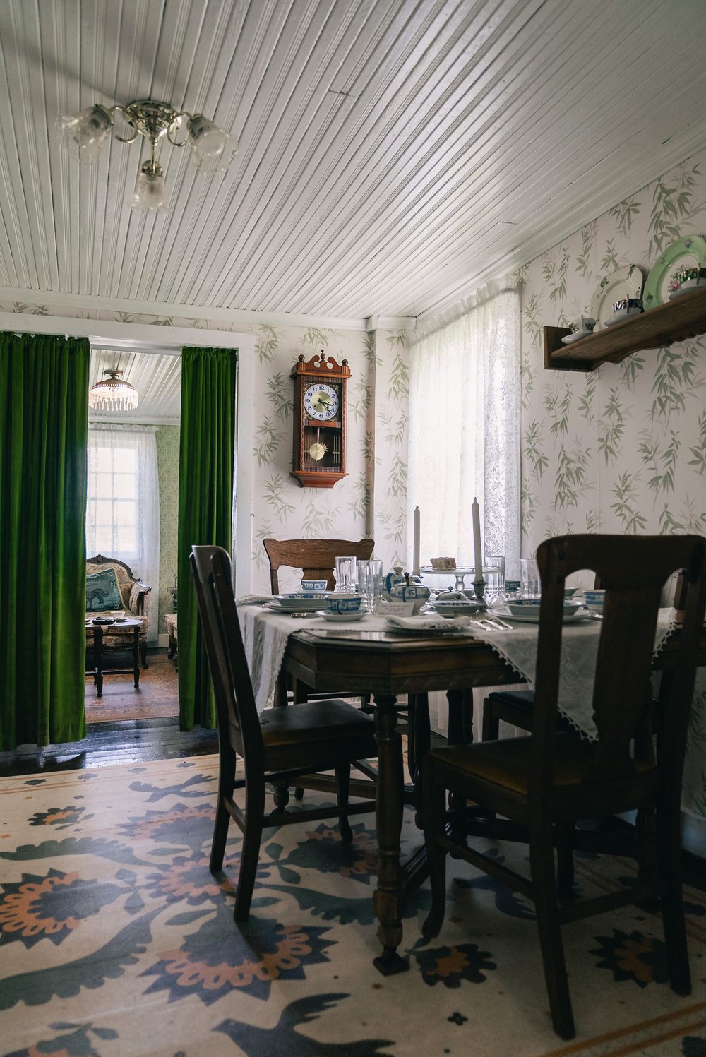 Vintage dining room with pale green bamboo-leaf botanical wallpaper and a set table